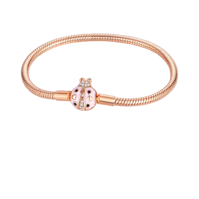 Rose gold bracelet with a decorative clasp on a light pink background