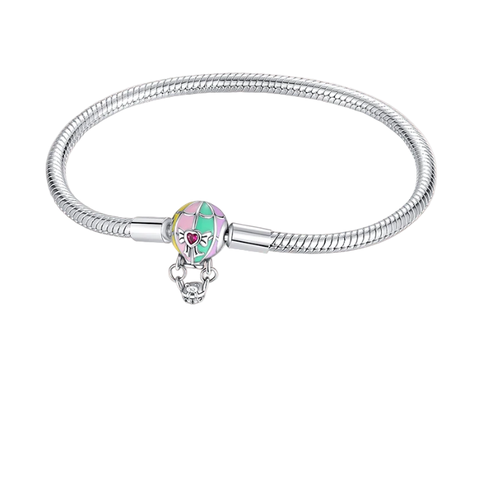 Silver bracelet with a heart-shaped charm on a pink background